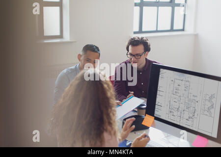 Les concepteurs travaillant, brainstorming at computer in office Banque D'Images