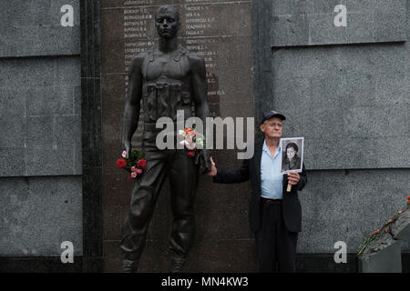 Un homme tient une photo d'une personne qui a combattu dans la seconde guerre mondiale au cours de la Journée de la victoire le 9 mai qui commémore la victoire de l'Union soviétique sur l'Allemagne nazie dans le Mémorial de la gloire qui commémore les anciens combattants et les morts de la Seconde Guerre mondiale, la guerre soviéto-afghane, et de la guerre de Transnistrie 1990-1992 situé sur place Souvorov Tiraspol dans la capitale et le centre administratif de l'intérieur des frontières internationalement reconnues de la Moldova dans le cadre d'un contrôle de fait de la République moldave Pridnestrovian aussi appelée la Transnistrie (PMR) depuis 1992. Banque D'Images