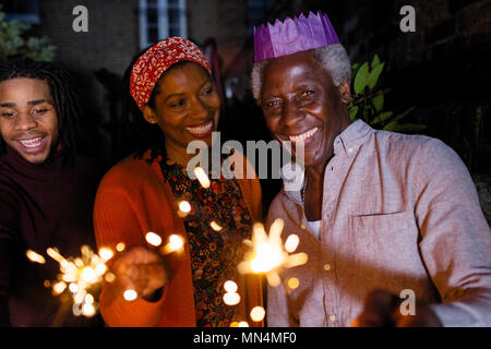 Portrait of smiling senior père avec baguettes en papier couronne fête avec fille Banque D'Images
