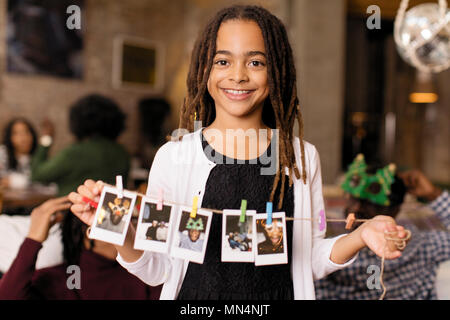 Portrait of smiling girl holding string de instant photos Banque D'Images