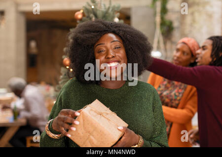 Portrait souriant, confiant young woman holding Christmas Gift Banque D'Images