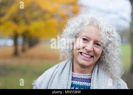 Portrait of smiling senior woman in autumn park Banque D'Images