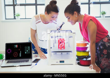 Les concepteurs de femme regardant imprimante 3D in office Banque D'Images