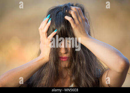 Jeune femme misérable head in hands outdoors Banque D'Images