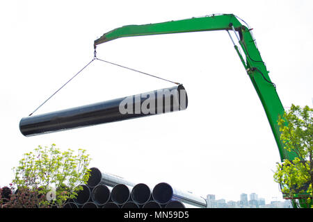 Chargement de produits sidérurgiques et de conduites d'eau avec une zone de stockage dans un camion avec une grue. Banque D'Images