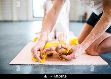 Méconnaissable senior male physiothérapeute travaillant avec une jeune patiente. Banque D'Images