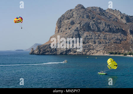 Le parapente les touristes sur l'île de Rhodes avec vue sur le mont Tsambika (Grèce). Deux parachutes-un avec l'inscription "Rhodes", en français, et t Banque D'Images