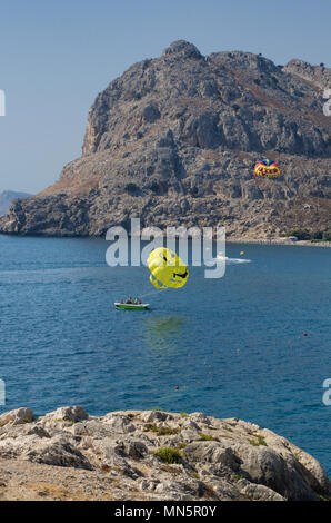 Le parapente les touristes sur l'île de Rhodes avec vue sur le mont Tsambika (Grèce). Deux parachutes-un avec l'inscription "Rhodes", en français, et t Banque D'Images