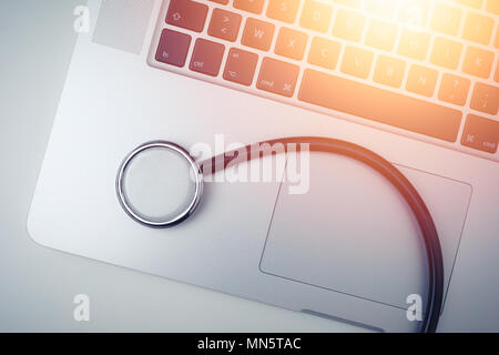 Un stéthoscope à proximité d'un ordinateur portable sur une table avec la lumière du soleil ou de l'ordinateur médical . service concept . Banque D'Images