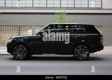 Vue latérale d'un Range Rover VUS pleine grandeur en stationnement sur une rue du centre-ville de Chicago. Banque D'Images