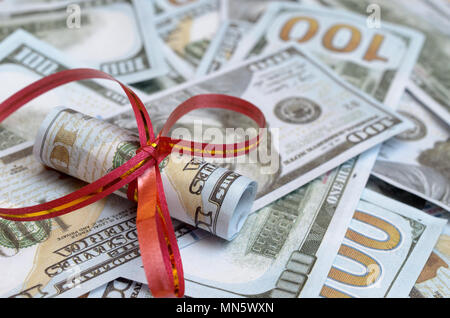 Rouleaux de l'argent dans un ruban cadeau sur lettres de dollars et d'euros Banque D'Images