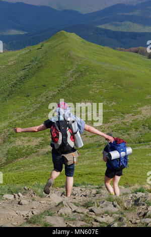 Deux randonneurs randonnée en partant du haut de la colline sur printemps journée ensoleillée en Bieszczady Carpates en Pologne. Banque D'Images