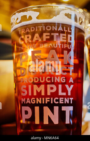 Rayons de soleil brillant à travers une pinte de bière sur une table. Le pub est le Peacock Inn de Bakewell et la bière est brassée localement. Banque D'Images