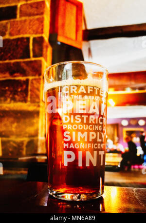 Rayons de soleil brillant à travers une pinte de bière sur une table. Le pub est le Peacock Inn de Bakewell et la bière est brassée localement. Banque D'Images