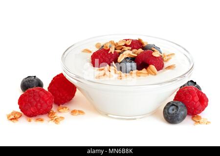 Cuve transparente de yaourt avec les framboises et les bleuets sur fond blanc Banque D'Images