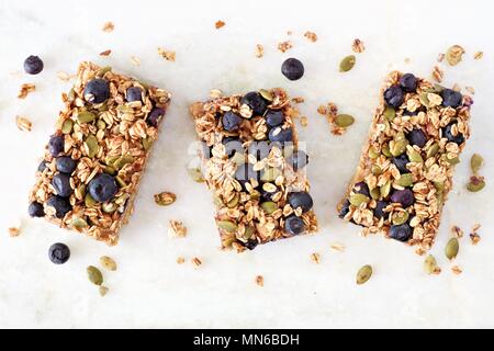 Superfood barres pour petit déjeuner avec l'avoine et aux bleuets, vue ci-dessus sur fond de marbre blanc Banque D'Images