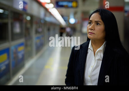 Belle mature Asian businesswoman à l'intérieur de la rame de métro sta Banque D'Images