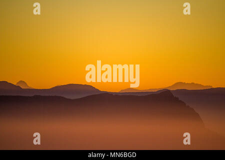 Le ciel est orange sur un lointain barn bluff et Cradle Mountain Banque D'Images