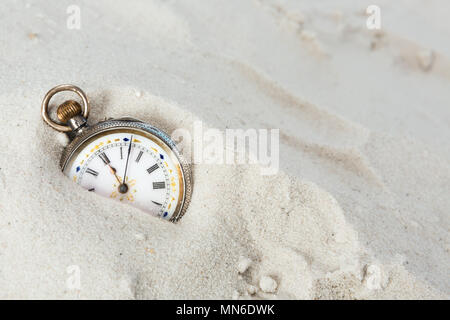 Belle ancienne montre de poche située dans le sable de plage Banque D'Images