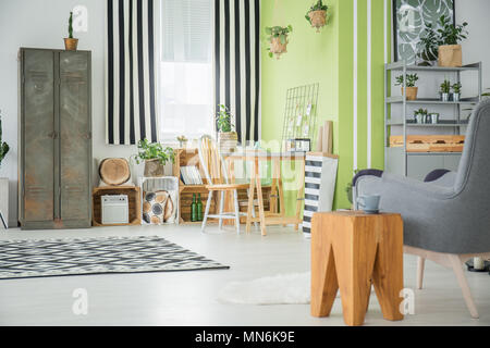 Cet appartement lumineux à la vieille armoire, fauteuil et mobilier de palettes Banque D'Images