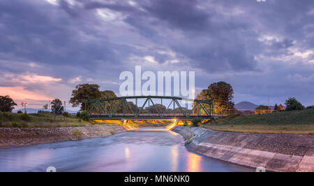 Eclaircir, iconique, pont ferroviaire métallique à Zajecar, Serbie, sur la rivière l'eau soyeuse Nisava et ciel coucher de soleil spectaculaire Banque D'Images