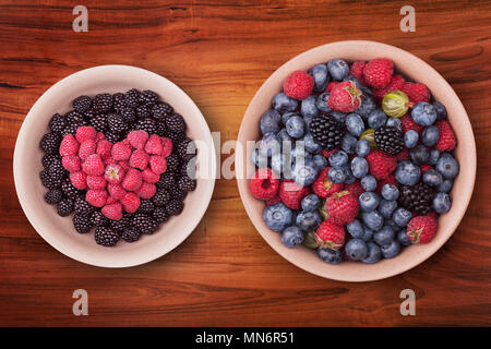 Plaques en céramique avec des petits fruits en forme de cœur sur la table en bois avec chemin de détourage. Vue d'en haut. Banque D'Images