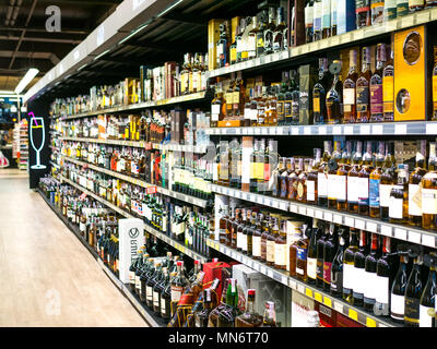 Image floue de vin étagères avec étiquettes de prix sur l'affichage à l'entreposer dans Kharkov, Uktaine. Defocused rangées de bouteilles d'alcool de vin sur l'étagère de supermarché. Banque D'Images