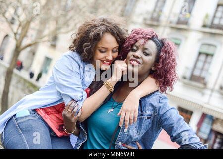 Portrait de deux belles filles en milieu urbain, noir et backgrund femmes mixte. Amis parler Banque D'Images