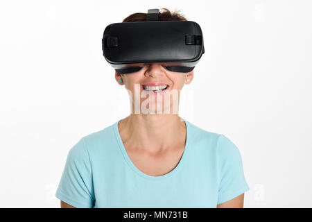 Femme à lunettes et gesticulant en VR avec ses mains. Belle surprise femme portant des lunettes de réalité virtuelle à regarder des films ou jouer à des jeux vidéo, isolé sur fond blanc. Banque D'Images