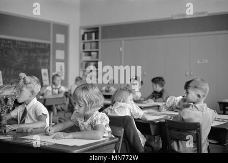 Les enfants dessin à un bureau dans la salle de classe, Greenhills, Ohio, aux États-Unis, une communauté de verdure construit par département américain de l'Agriculture dans le cadre du président Franklin Roosevelt, le New Deal américain John Vachon pour la réinstallation de l'Administration, Octobre 1938 Banque D'Images