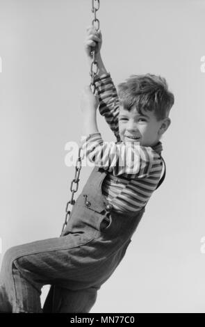 Portrait de jeune garçon accroché sur la chaîne au niveau de l'aire de rotation, de l'enfant travailleur migrateurs, Midland, Texas, USA, Arthur Rothstein pour Farm Security Administration, Janvier 1942 Banque D'Images