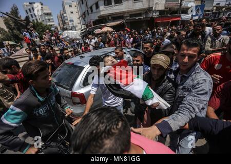 La bande de Gaza. 15 mai, 2018. En deuil et les parents portent le corps de huit mois bébé palestinienne Laila al-Ghandour, qui est mort après avoir inhalé des gaz lacrymogènes lors d'une manifestation à la frontière Israel-Gaza dans la ville de Gaza, le 15 mai 2018. Le lundi, les forces israéliennes ont tué des dizaines de Palestiniens et blessé plus de 2 000 autres dans une confrontation d'une journée le long de la frontière de Gaza et Israël. Credit : Wissam Nassar/Xinhua/Alamy Live News Banque D'Images