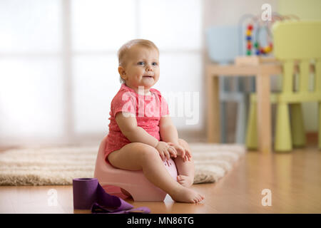 Bébé l'apprentissage de l'utilisation de pot de chambre Banque D'Images