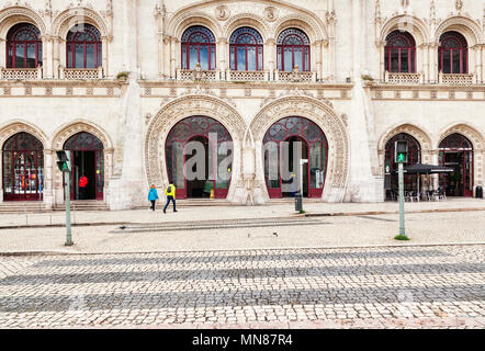 3 mars 2018 : Lisbonne, Portugal - la façade à arcades de la gare Rossio, un couple à faire leur chemin à l'entrée. Au premier plan un pélican c Banque D'Images