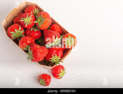 La fraise dans un panier en bois isolé sur fond blanc Banque D'Images