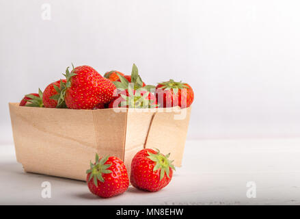 La fraise dans un panier en bois isolé sur un fond blanc close up Banque D'Images