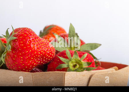 La fraise dans un panier en bois isolé sur un fond blanc close up Banque D'Images