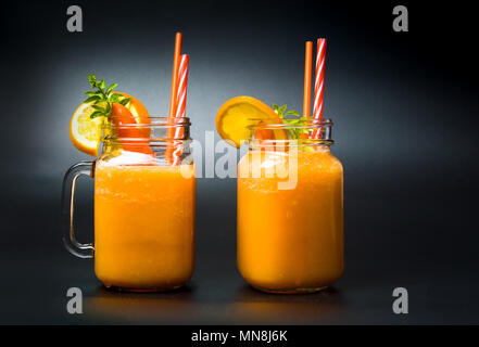 Carotte et orange smoothies aux fruits mélangés dans des bocaux Banque D'Images