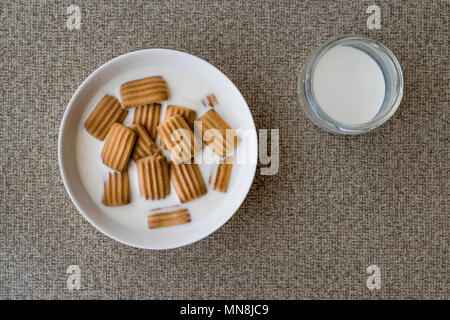 Biscuit bébé avec du lait dans un bol blanc. Concept d'aliments pour bébés. Banque D'Images