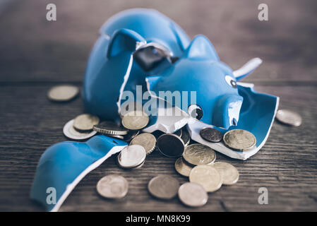 Shattered broken piggy bank with coins sur table en bois rustique Banque D'Images