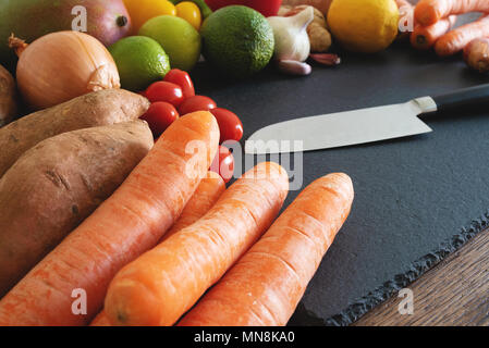 Les fruits et légumes frais biologiques sur ardoise planche à découper, couteau de cuisine Banque D'Images