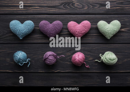 Artisanat coloré hearts & bonneterie écheveaux de fil sur l'ancienne table en bois gris. Palette de couleurs rétro. Faire un message d'amour Banque D'Images