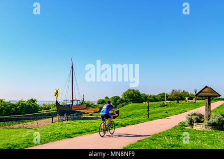 Cycliste passant devant le Hugin, réplique d'un bateau viking à Cliffsend près de Ramsgate UK Banque D'Images