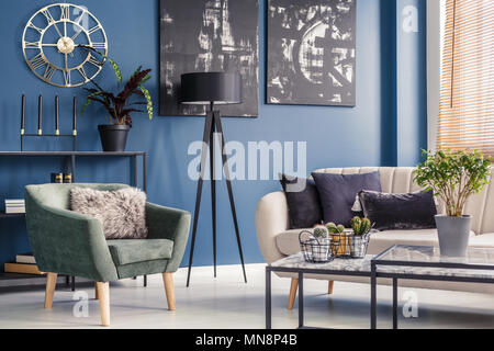 Décoration élégante, coussins sur un canapé beige et vert menthe moderne un fauteuil dans un salon intérieur bleu Banque D'Images