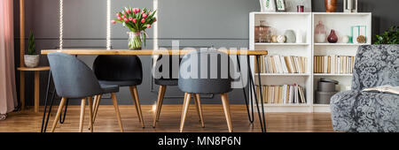 Quatre chaises gris debout par une épingle à l'intérieur de la table de salle à manger avec coin lecture Banque D'Images