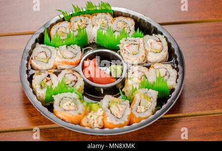 Grand ensemble de rouleaux de sushi japonais sur une plaque en plastique noir Banque D'Images
