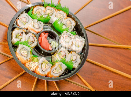 Grand ensemble de rouleaux de sushi japonais sur une plaque en plastique noir Banque D'Images