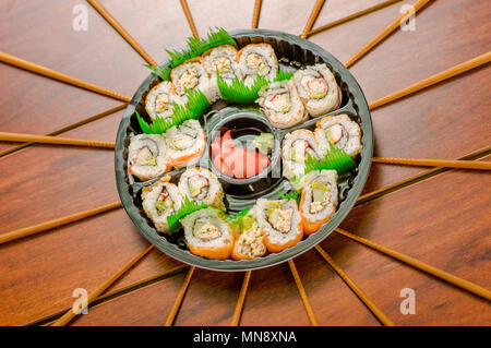 Grand ensemble de rouleaux de sushi japonais sur une plaque en plastique noir Banque D'Images