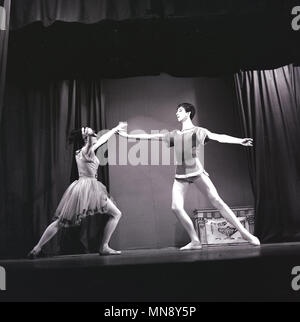 1965, deux jeunes danseurs en costume adultes performing ballet sur une scène, England, UK. Le mouvement du corps et la posture sont des éléments clés de la performance de ballet et l'on peut voir ici l'importance de 'Alignement', en gardant la tête, les épaules et les hanches alignées verticalement ''. Banque D'Images