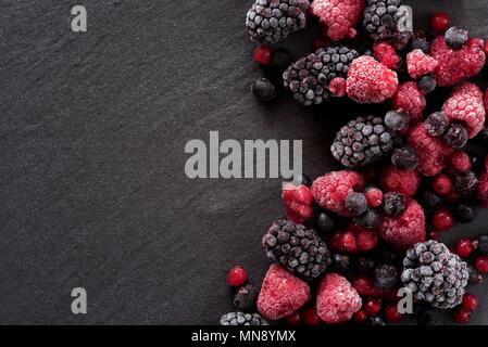 Les baies d'été gelés sur un arrière-plan en ardoise, blackberry, framboises et groseilles. Banque D'Images